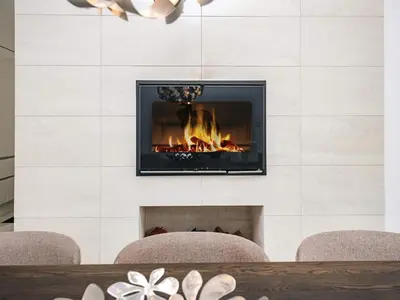 a fireplace with two chairs in front of it at 4 star holiday home in Blokhus in Blokhus