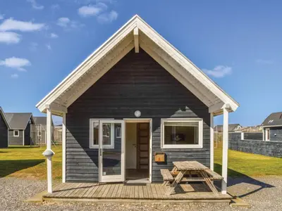 a small black tiny house with a picnic table at 4 star holiday home in Thyborøn in Thyborøn