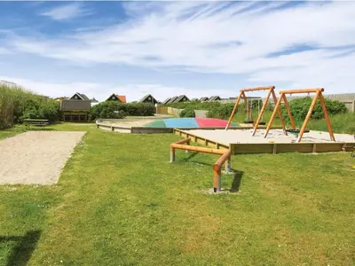 a park with two swings and a playground at 4 star holiday home in Thyborøn in Thyborøn