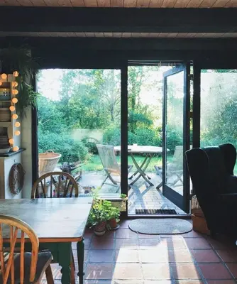 a screened in porch with a table and chairs at Lovely Tiny House On A Nature Plot Near Limfjord in Roslev