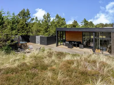 a modern house with a black exterior and trees at Lovely Holiday Home With Outdoor Sauna And Wilderness Bath, Close To Klitmøller Center And The North Sea in Torsted