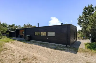 a black house on top of a dirt road at Lovely Holiday Home With Outdoor Sauna And Wilderness Bath, Close To Klitmøller Center And The North Sea in Torsted