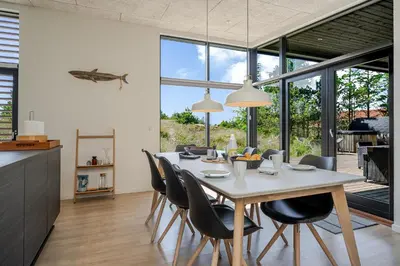 a kitchen and dining room with a table and chairs at Lovely Holiday Home With Outdoor Sauna And Wilderness Bath, Close To Klitmøller Center And The North Sea in Torsted