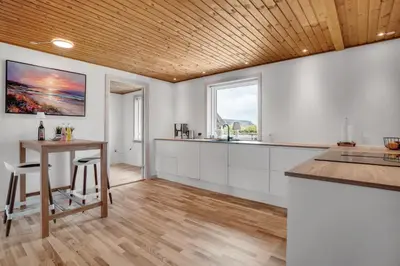 a kitchen with white cabinets and a wooden ceiling at Lovely Holiday Home With Fenced Plot, 300 Meters From The North Sea In Thy in Lild Strand