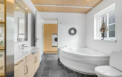 a bathroom with a tub and a sink and a toilet at Holiday Home Spøttrup - 04 in Spottrup