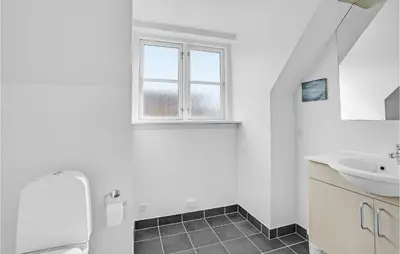 a white bathroom with a sink and a window at Holiday Home Spøttrup - 04 in Spottrup