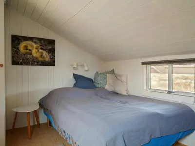 a bedroom with a bed in a room with a window at Holiday Home Overlooking Protected Dune Heath in Frøstrup