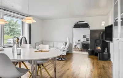 a kitchen and living room with a white table and chairs at Stunning Home In Blokhus With Wifi in Blokhus