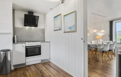 a kitchen with a stove and a dining room at Stunning Home In Blokhus With Wifi in Blokhus