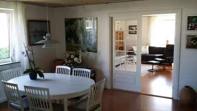 a dining room and living room with a table and chairs at Bed & Breakfast i Vorupør in Nørre Vorupør