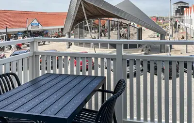 a blue wooden bench on a balcony with a market at Cozy Apartment In Blokhus With Wifi in Blokhus