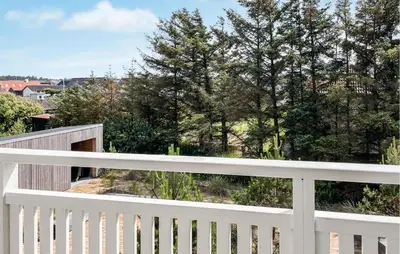 a white fence on a balcony with trees at Cozy Apartment In Blokhus With Wifi in Blokhus
