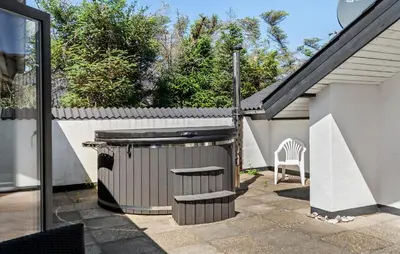 a patio with a trash can and a chair at Amazing Home In Thisted With Sauna in Thisted