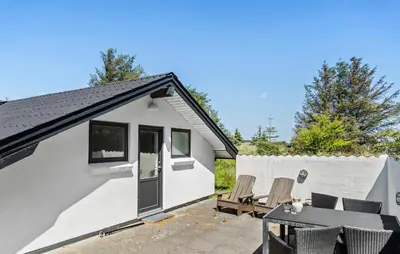 a small white house with a table and chairs at Amazing Home In Thisted With Sauna in Thisted