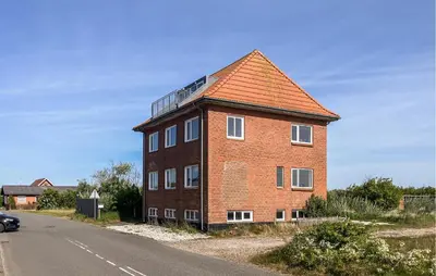 a brick building with a roof on the side of a road at Amazing Home In Harboøre With Wifi in Harboør