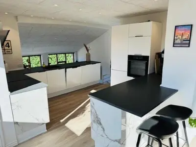 a kitchen with black counter tops and white cabinets at Villa Centrum in Holstebro