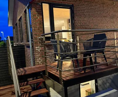 two chairs sitting on a deck next to a building at Villa Centrum in Holstebro