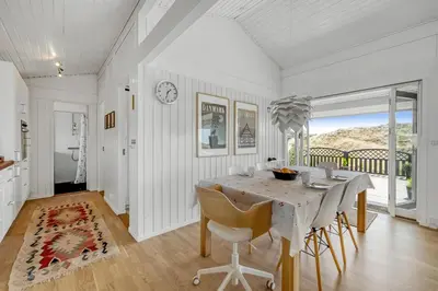 a white dining room with a table and chairs at Forårsvangen 2 in Saltum