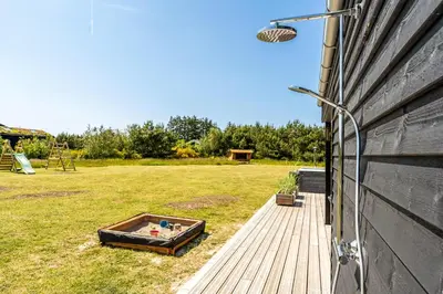 a garden with a hot tub on the side of a house at Laustvej 3 in Saltum