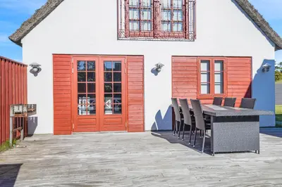 a patio with a table and chairs in front of a house at 3009Møllehuset, Begge Huse in Blokhus
