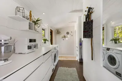 a white laundry room with a washer and dryer at Granlien 3, A Holiday Home With Soul And Charm! in Blokhus