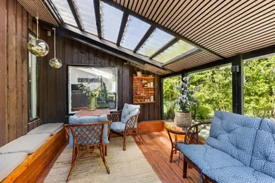 a conservatory with a table and chairs on a deck at Granlien 3, A Holiday Home With Soul And Charm! in Blokhus