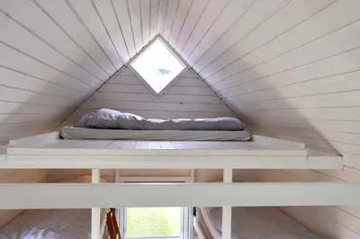 a bed in a tiny house with a window at Aalborg Hytteø in Aalborg
