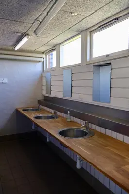 two sinks in a public restroom with two mirrors at Aalborg Hytteø in Aalborg