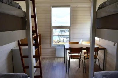 a small room with a table and chairs and a table and bunk beds at Aalborg Hytteø in Aalborg