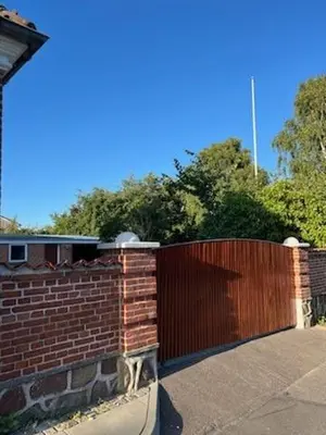 a red brick fence with a wooden gate at VillaRanum in Ranum