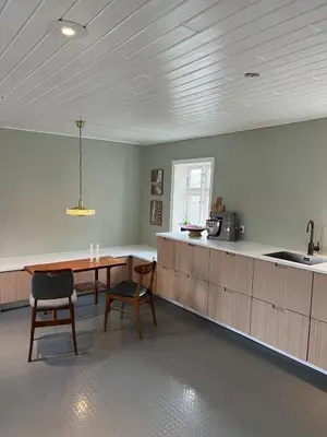 a kitchen with a table and chairs and a sink at VillaRanum in Ranum