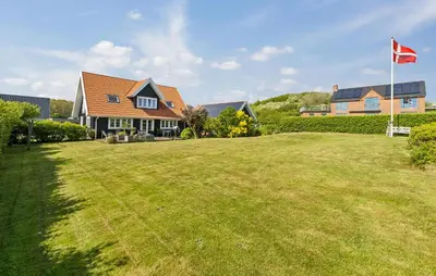 a house with a flag on a large yard at Amazing Home In Spøttrup in Spottrup