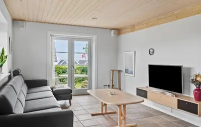 a living room with a couch and a tv at Amazing Home In Spøttrup in Spottrup