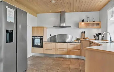 a kitchen with wooden cabinets and a stainless steel appliance at Amazing Home In Spøttrup in Spottrup