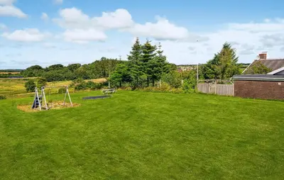 a yard with a swing set in the grass at 2 Bedroom Pet Friendly Home In Thisted in Thisted
