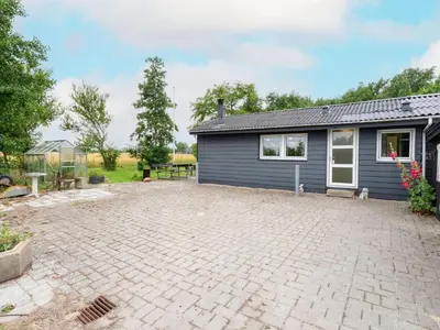 a house with a brick driveway in front of a garage at 6 person holiday home in Thyholm in Thyholm