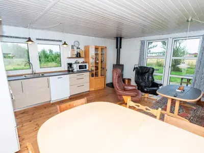 a kitchen and dining room with a table and chairs at 6 person holiday home in Thyholm in Thyholm
