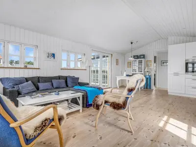 a living room with a couch and a table and chairs at Holiday Home Thine - 250m from the sea by Interhome in Harboør
