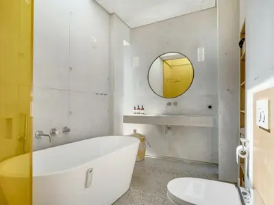 a bathroom with a white tub and a yellow mirror at Holiday Home Rieke - 250m from the sea by Interhome in Torsted