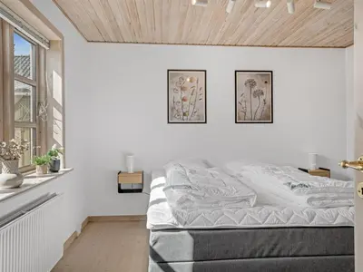 a white bedroom with a bed and a window at Holiday Home Antine - 400m from the sea by Interhome in Thyborøn