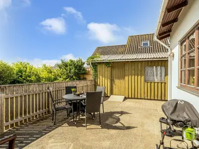 a patio with a table and chairs and a fence at Holiday Home Antine - 400m from the sea by Interhome in Thyborøn