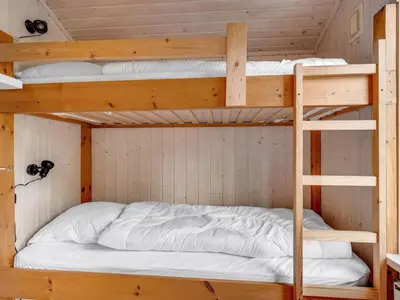 two bunk beds in a cabin with white sheets at Holiday Home Iris - 200m to the fjord by Interhome in Thyholm
