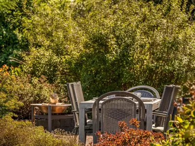 three chairs and a table and a table and a table and chairsitures at Holiday Home Elia - 5km to the fjord by Interhome in Spottrup