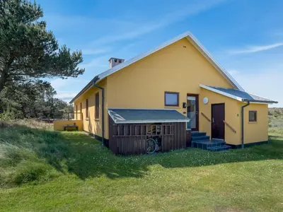 a small yellow house on a grass field at Holiday Home Ola - 900m from the sea by Interhome in Bedsted Thy