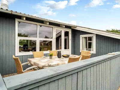 a deck with a table and chairs on a house at Holiday Home Claudine - 700m from the sea by Interhome in Thisted