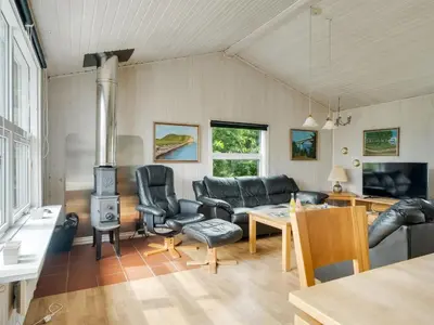 a living room with a couch and a stove at Holiday Home Claudine - 700m from the sea by Interhome in Thisted