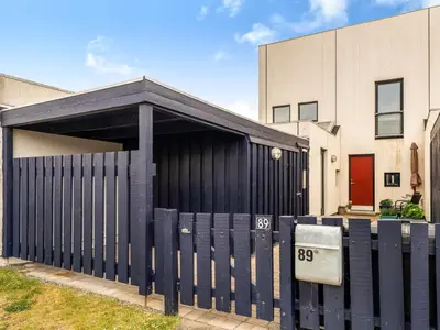 a black garage with a black gate in front of a building at Holiday Home Nis - 900m from the sea by Interhome in Blokhus