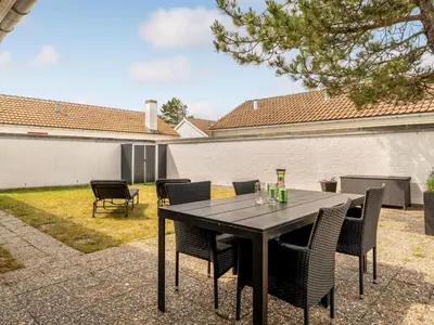 a black table with chairs and drinks on a patio at Holiday Home Aike - 1km from the sea by Interhome in Pandrup