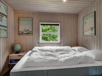 a bedroom with a white bed and a window at Holiday Home Ginette - 400m to the fjord by Interhome in Åbybro