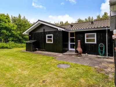 a black shed with a lawn in front of it at Holiday Home Ginette - 400m to the fjord by Interhome in Åbybro